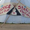 Un tipi avec l'inscription en anglais « Justice for Our Stolen Children ».