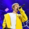 Justin Bieber, microphone à la main, chante sur scène lors d'un concert.