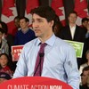 Justin Trudeau debout au podium, alors qu'on voit plusieurs partisans libéraux derrière lui.