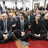 Ils sont sur un tapis avec les jambes croisées.