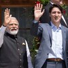 Narendra Modi et Justin Trudeau saluent la foule de la main.