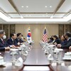 La vice-présidente américaine, Kamala Harris, est assise face au président sud-coréen, Yoon Suk-yeol, autour d'une table avec leurs conseillers. 