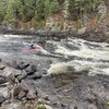 Un kayakiste dans une rivière à fort débit.
