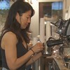 Une femme prépare du café dans un commerce.