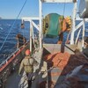 Des pêcheurs au travail sur un bateau de pêche à la crevette.