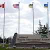 Vue de l'entrée de l'aéroport international de Regina avec des drapeaux qui flottent.