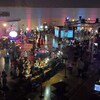 Une salle remplie d'écrans et de gens en train de jouer à des jeux vidéo.