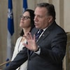 François Legault et la ministre responsable des Relations canadiennes et de la Francophonie canadienne, Sonia LeBel derrière un micro.