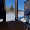 Un homme est debout devant une plateforme en métal, entourée de panneaux en métal.