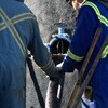 Deux ouvriers sont en train de nettoyer un puits de pétrole abandonné près de Frog Lake, en Alberta, en octobre 2022.