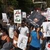 Des Libanais manifestent dans la rue avec des pancartes. 