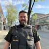 Le lieutenant Gabriel Poirier au centre-ville de Rouyn-Noranda. La police de caractère du mot Police sur sa veste a été changé pour les couleurs de la communauté LGBTQ+.