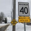 Une pancarte routière jaune signale une nouvelle limite de vitesse
