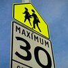 Panneau de signalisation indiquant une limite de vitesse de 30 km/h dans une zone scolaire