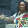 Linda Kongnetiman parle devant un pupitre en verre.