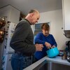 Debout dans la cuisine, Lisa Garner aide son client Paul à préparer son repas.