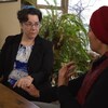 Lisa Grushcow (à gauche) et Amal Elsana-Alhjooj (à droite) sont assises et se tiennent par la main en discutant.