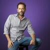 Portrait de Luke Perry sur un fond violet. 