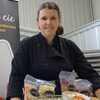 Sandra Mercier debout derrière un comptoir garni de ses produits.