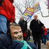 Un manifestant tient un masque à l'effigie du président français Emmanuel Macron.