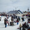 Des dizaines de personnes s'activent autour d'un chapiteau au centre-ville d'Amos, l'hiver.