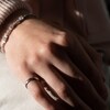 La main d'une femme qui porte un anneau à son petit doigt.