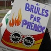 Une pancarte de manifestants qui porte la mention « Brûlés par Phénix ».