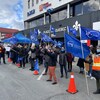 Des manifestants tenant des drapeaux de l'APTS devant la Place du Québec.