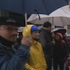 Des manifestants tenant des parapluies.