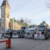 Des camions stationnés l'un à côté de l'autre lors d'une manifestation près du parlement du Canada.