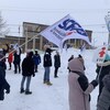 Une dizaine de personnes sont rassemblées devant l'hôtel de ville de Rouyn-Noranda. Certaines d'entre elles brandissent des drapeaux du Syndicat canadien de la fonction publique, de la Fédération des travailleurs du Québec et du Syndicat des Métallos.