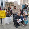 Des manifestants montrent leurs pancartes.