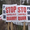 Des pancartes avec les mots : Arrêtez la carrière de Campbellville et Protéger l'eau de Milton.