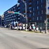 Des personnes en ligne le long d'un trottoir brandissent des pancartes.