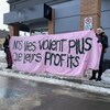 Deux manifestantes déploient une banderole sur laquelle on peut lire: Nos vies valent plus que leurs profits.