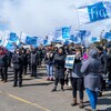 Des membres du Syndicat des professionnelles en soins de la Mauricie et du Centre-du-Québec dehors avec des drapeaux sur lesquels ont peut lire FIQ.