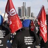 Des syndiqués portent des drapeaux d'Unifor et des vestes sur lesquelles il est écrit en anglais : « Le Canada n'a pas renfloué GM pour déménager nos emplois au Mexique ».