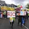 Des manifestants marchent en tendant des pancartes.