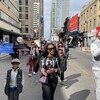 Des manifestants avec des porte-voix et des banderoles, marchant dans le centre-ville de Toronto.