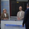 Les deux candidats portant des vestons beiges sur le plateau du Téléjournal regardent vers l'animateur Bruno Savard qui leur pose une question.