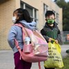Deux élèves portent le masque à l'extérieur d'une école à Toronto.