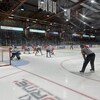 Des joueurs de l'Océanic et du Drakkar sur la glace pendant un match qu'un arbitre surveille.