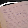 Image d'un livre ouvert avec des écritures à la main. 