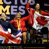 Christine Gauthier, assise dans un fauteuil roulant, célèbre en compagnie de deux autres athlètes.