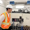 Un homme regarde une machine médicale avec le sourire. 