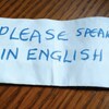 Un bout de papier sur lequel on peut lire en anglais : « Parlez anglais SVP ».