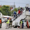Des Haïtiens descendent d'un avion à Port-au-Prince, après avoir été expulsés des États-Unis.