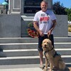 Mike Richards et son chien Félix devant un monument.