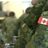 Un militaire porte un écusson du drapeau canadien sur son uniforme.