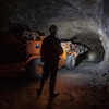 Un homme travaille avec un engin dans une mine.
